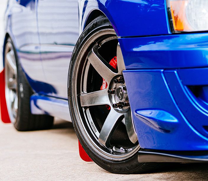 A close up of the wheel on a blue car