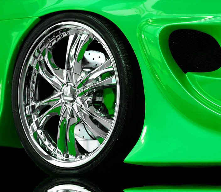 A close up of the wheel on a green car